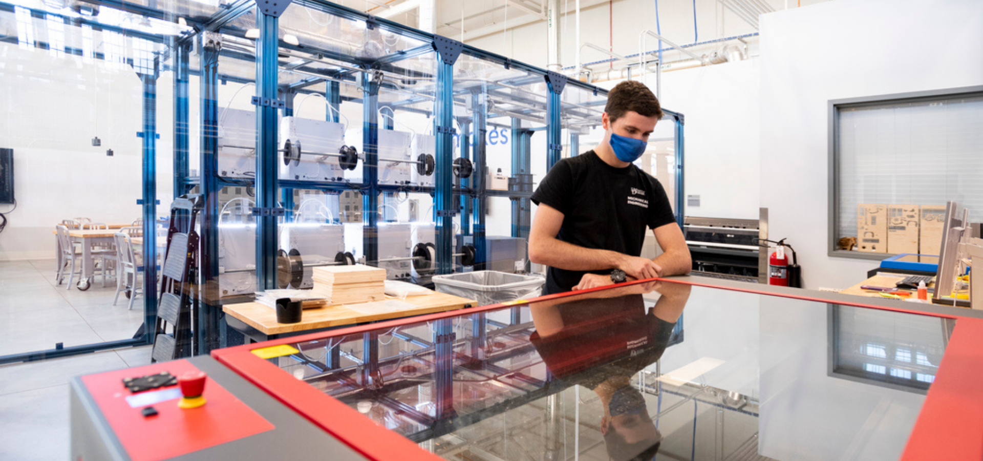 Student in an engineering lab in front of a CNC machine