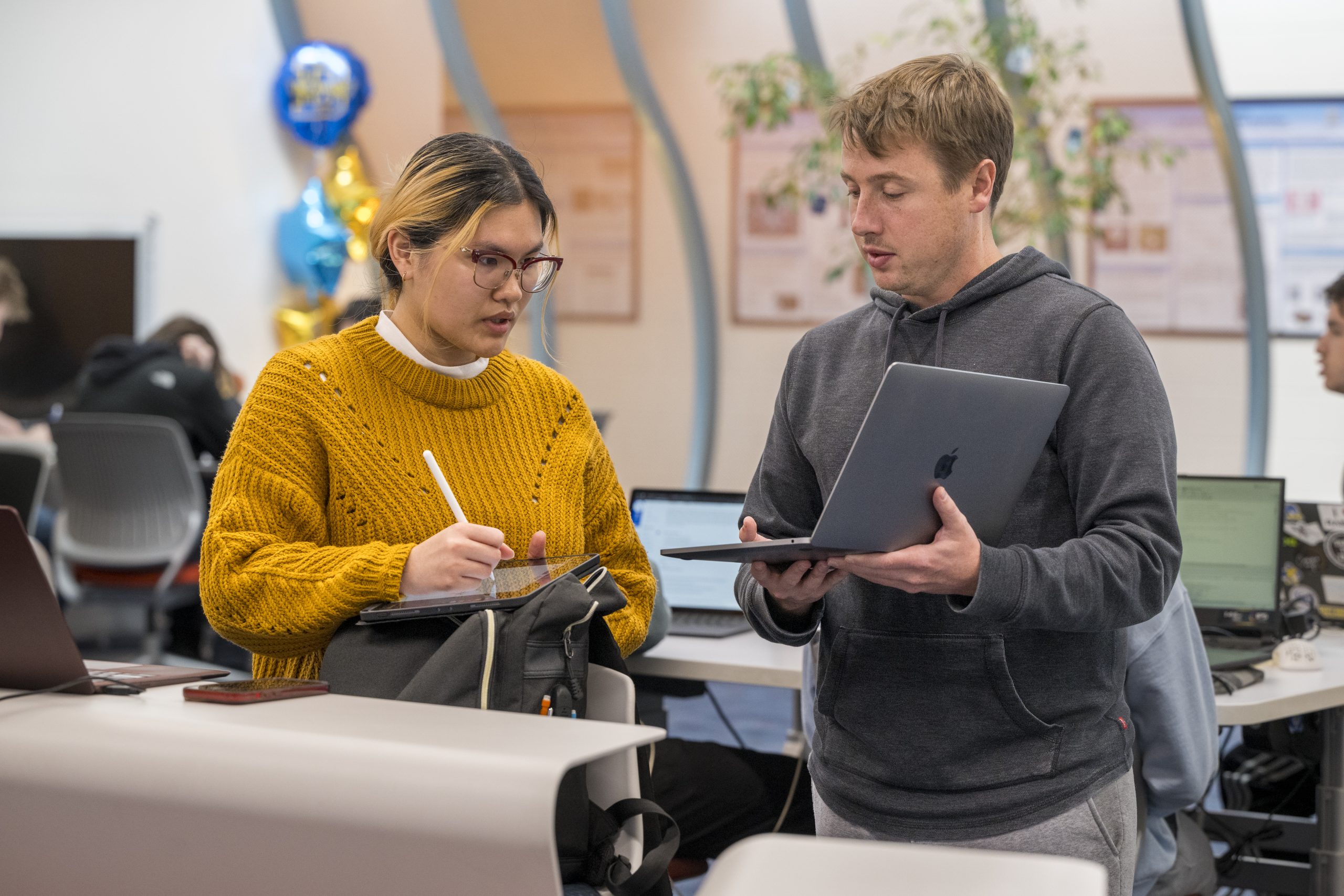 two students looking at a laptop